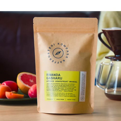 En påse fruktigt ljusrostat Rwanda Gasharu kaffe med aprikoser och grapefrukt i bakgrunden