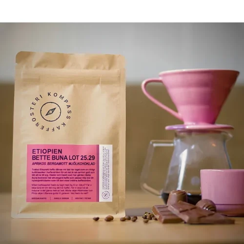 En påse Bette Buna från Kompass kafferosteri på ett bord med V60 och choklad